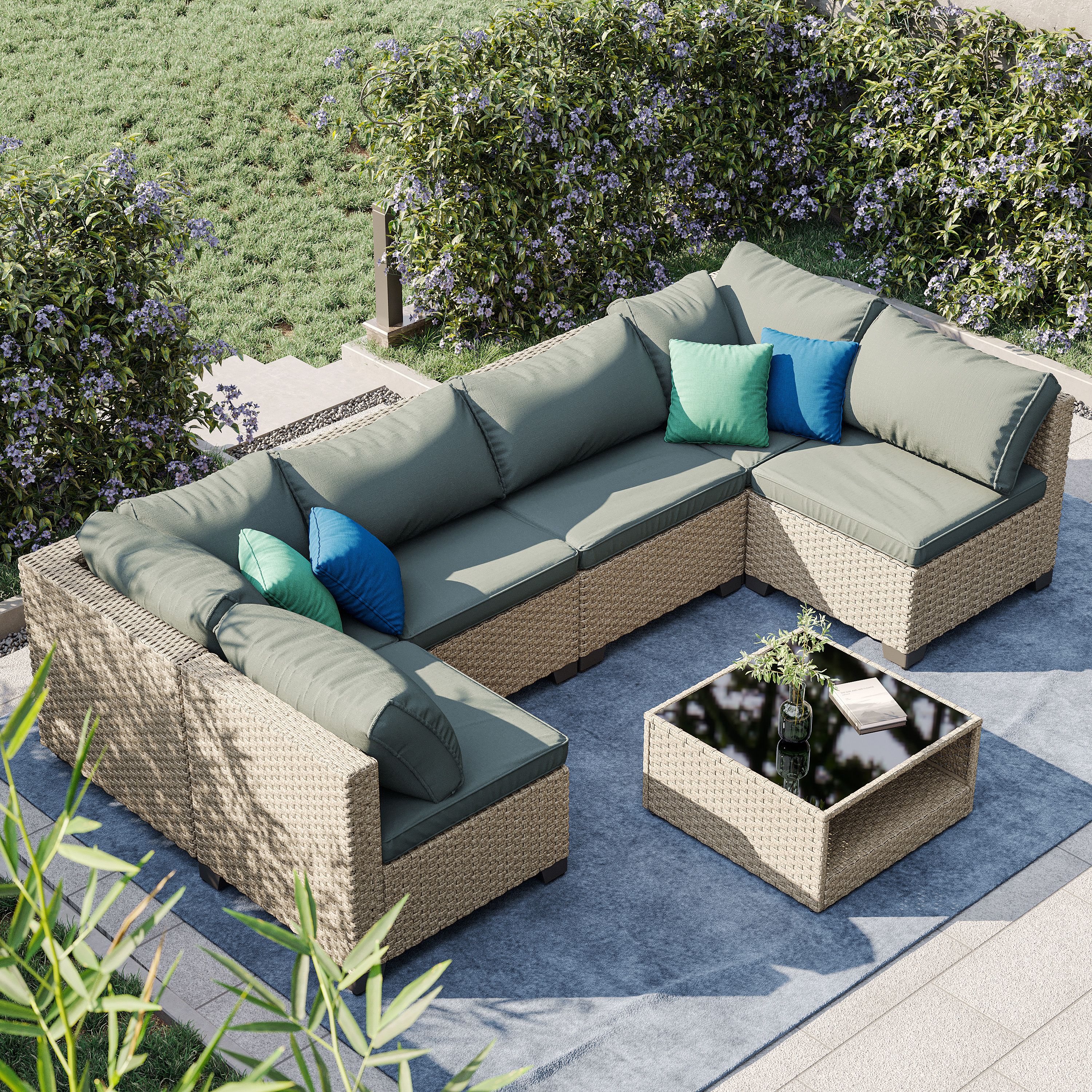 Grey cushions on a patio sofa with a glass-top coffee table nearby