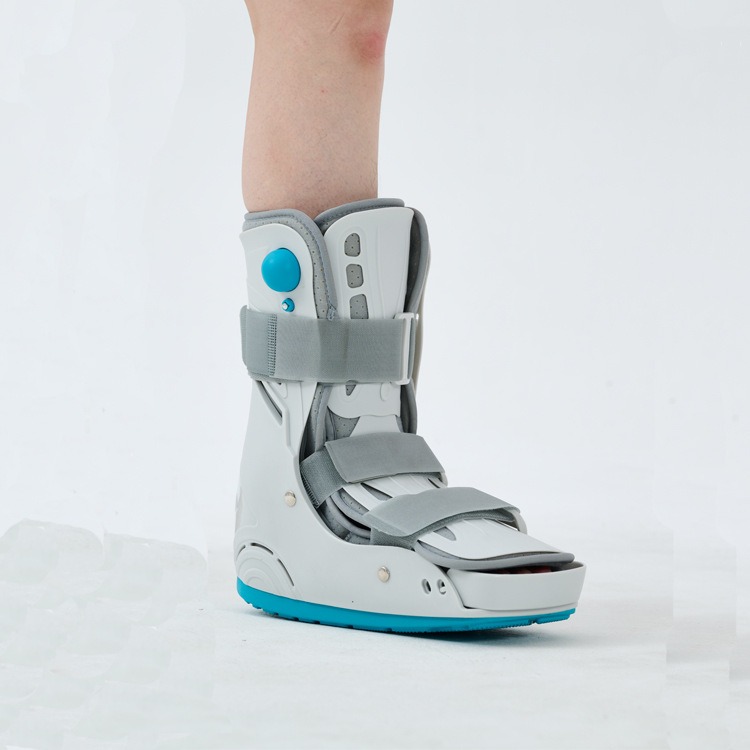 Person sitting with ankle boot, foot elevated on cushion, looking uncomfortable
