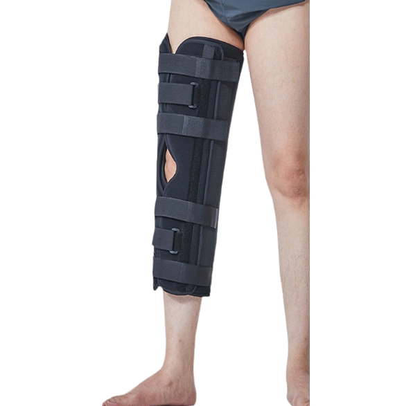 Male model wearing external fixation knee brace on right leg, standing upright showing full-length product in situ