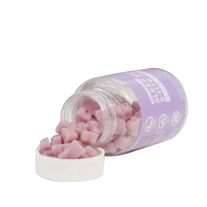 Pink gummies spilling from a tilted lavender glass jar, showing their appetizing texture and color.