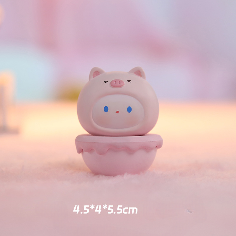 Small animal-costume figurine beside a pen for scale