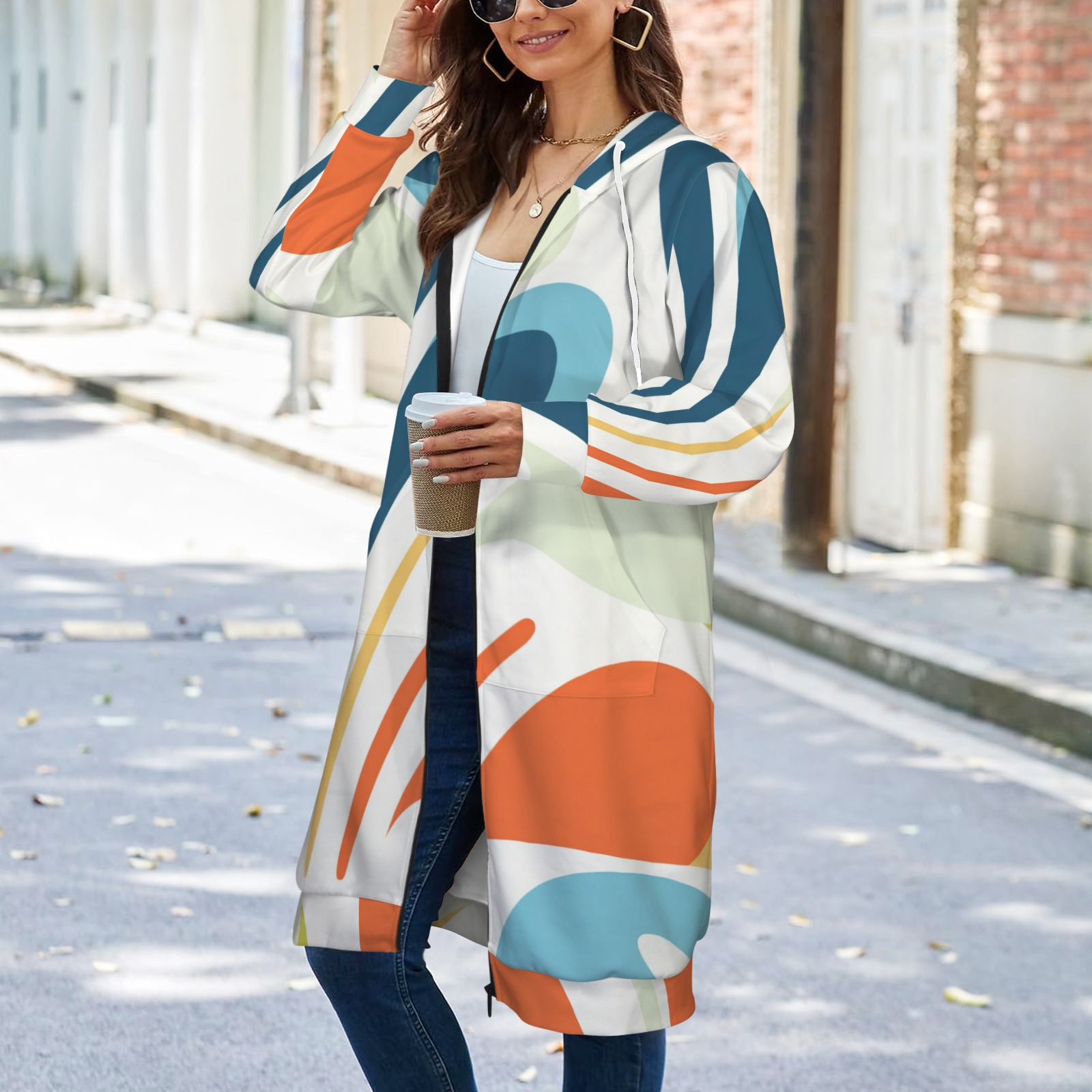 Women's long hooded coat with colorful abstract pattern, long sleeves and front pockets. A model wearing the coat.