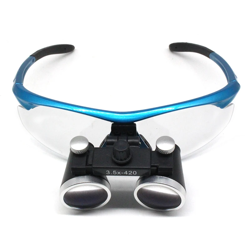 Blue surgical loupes shown on a neutral surface with lenses facing forward