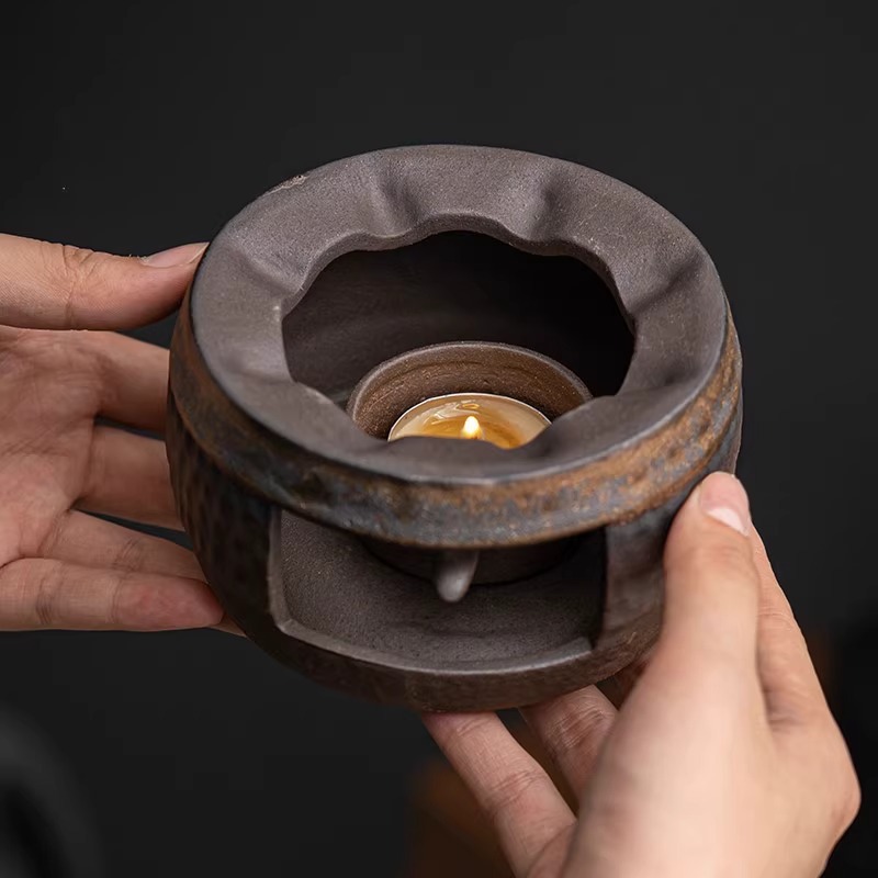 Stoneware warmer and teapot set on a wooden table at home