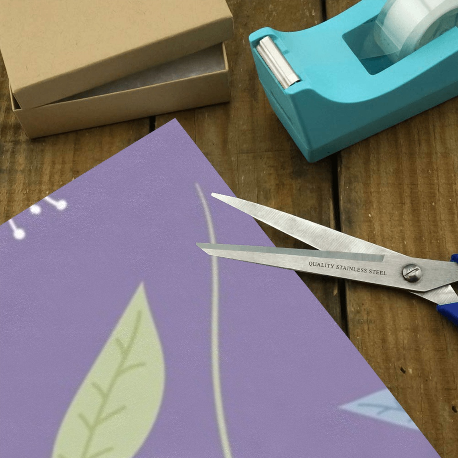 Cutting purple floral gift wrapping paper, perfect for gifts. Features floral design, scissors, tape dispenser.