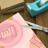 Cutting gift wrapping paper with scissors, pink pattern, ideal for gift wrapping