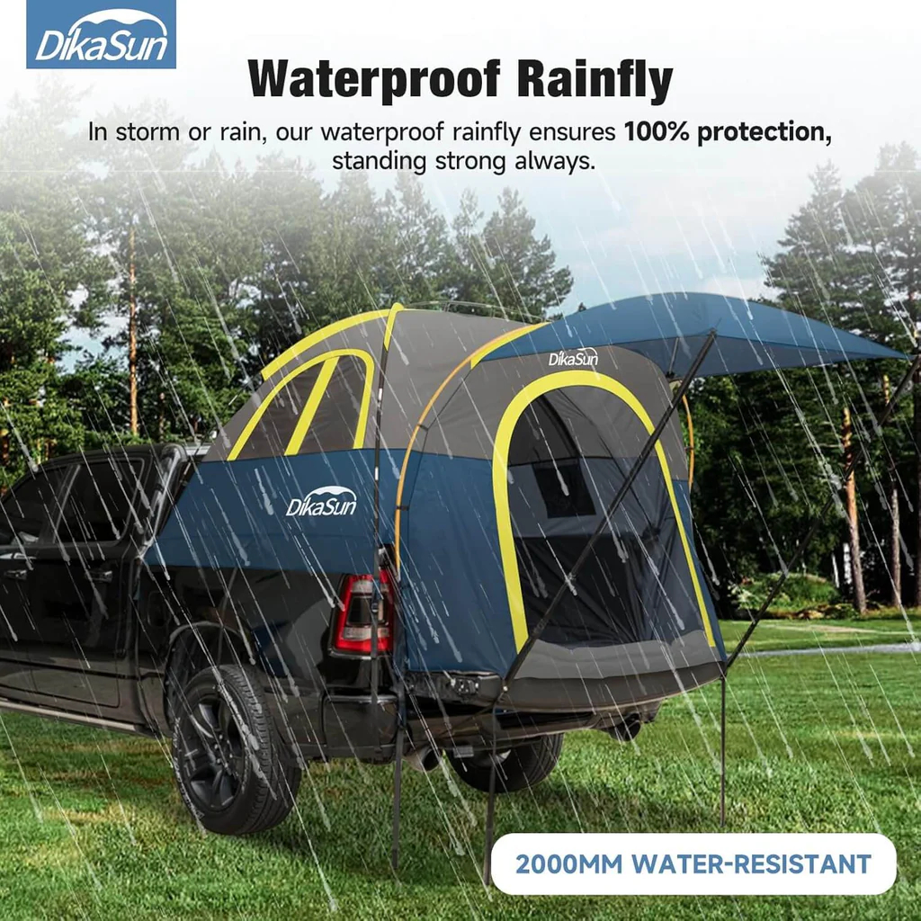 Waterproof rainfly shedding heavy rain over a truck bed tent on grass