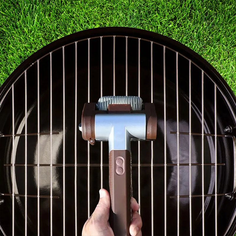 Electric grill brush cleaning a charcoal grill grate with debris lifting away