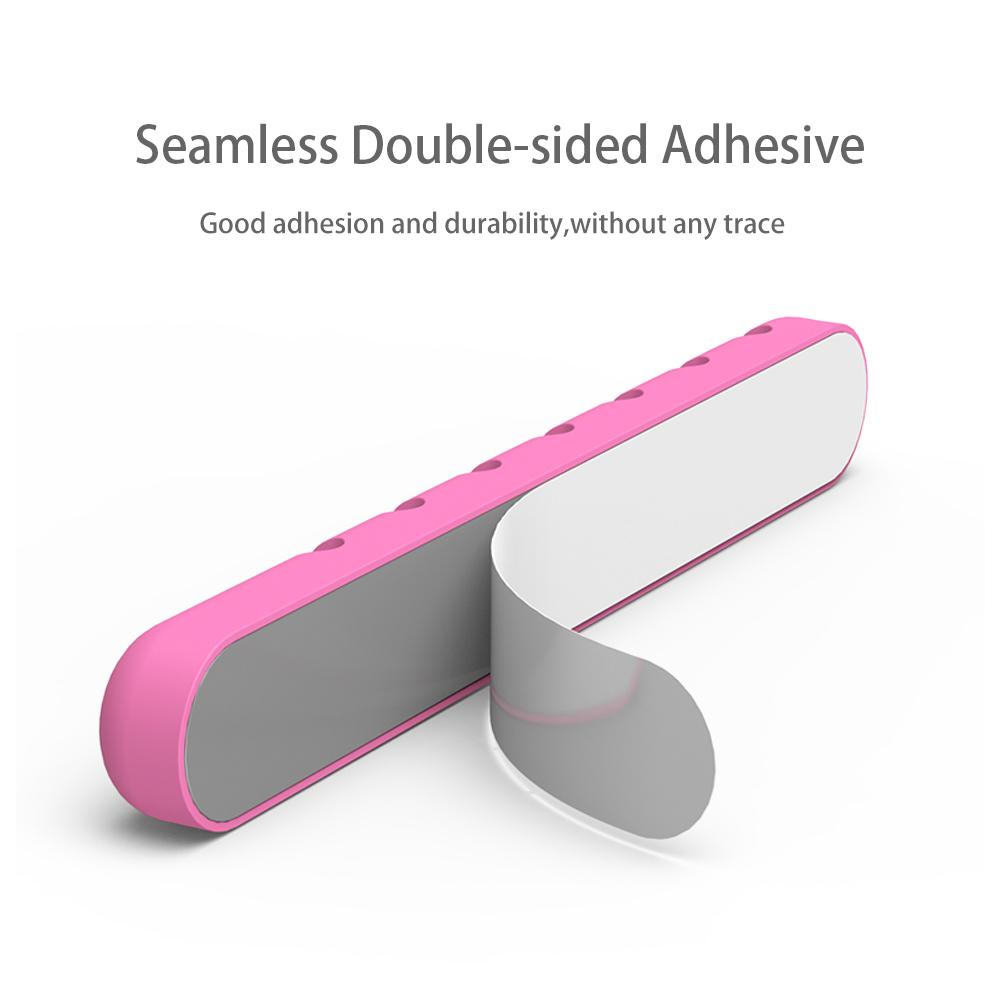 Back of a clip bar showing double-sided adhesive ready to press onto a desk