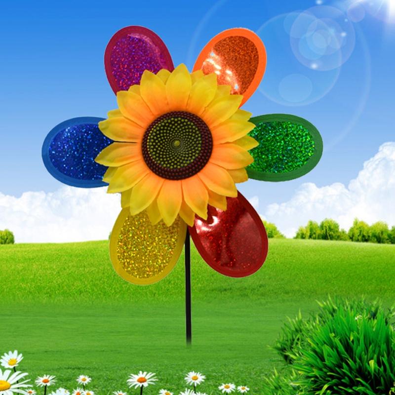 Sunflower wind spinner on a lawn under a bright blue sky