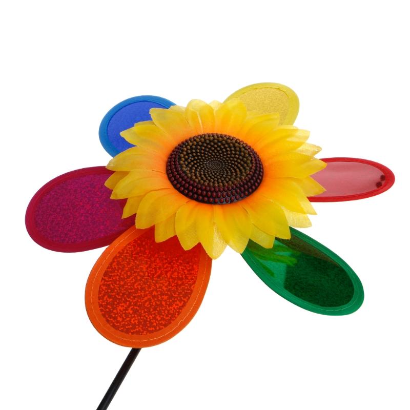 Sunflower wind spinner standing in a garden bed