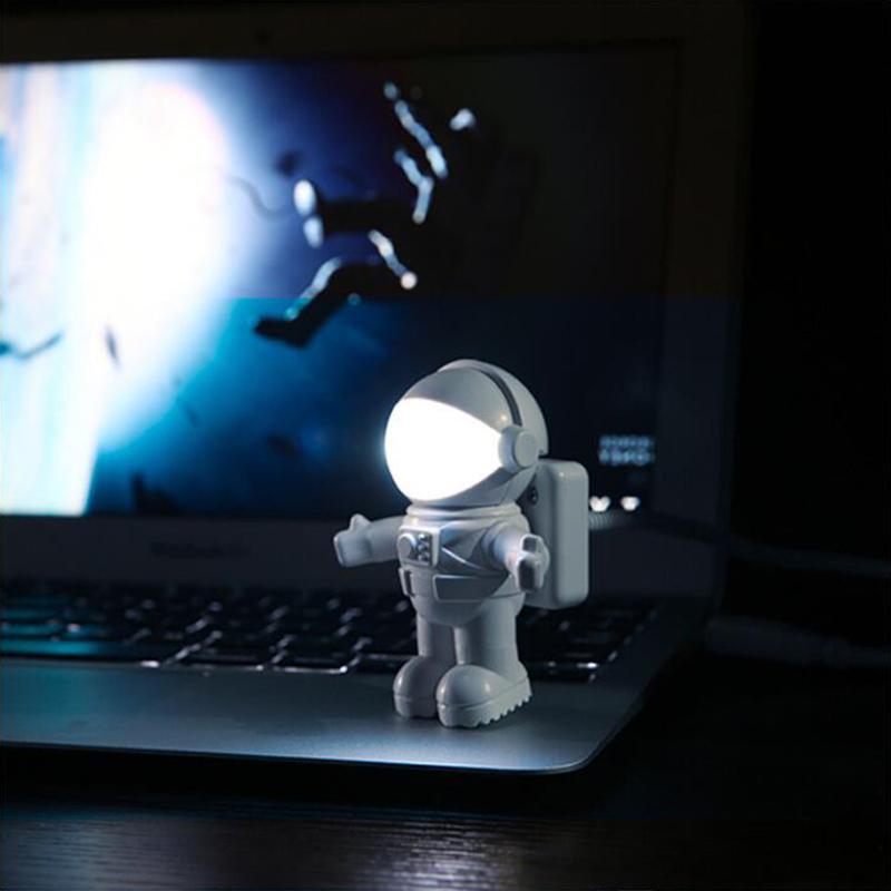 Astronaut USB lamp lighting a laptop keyboard in a dim room