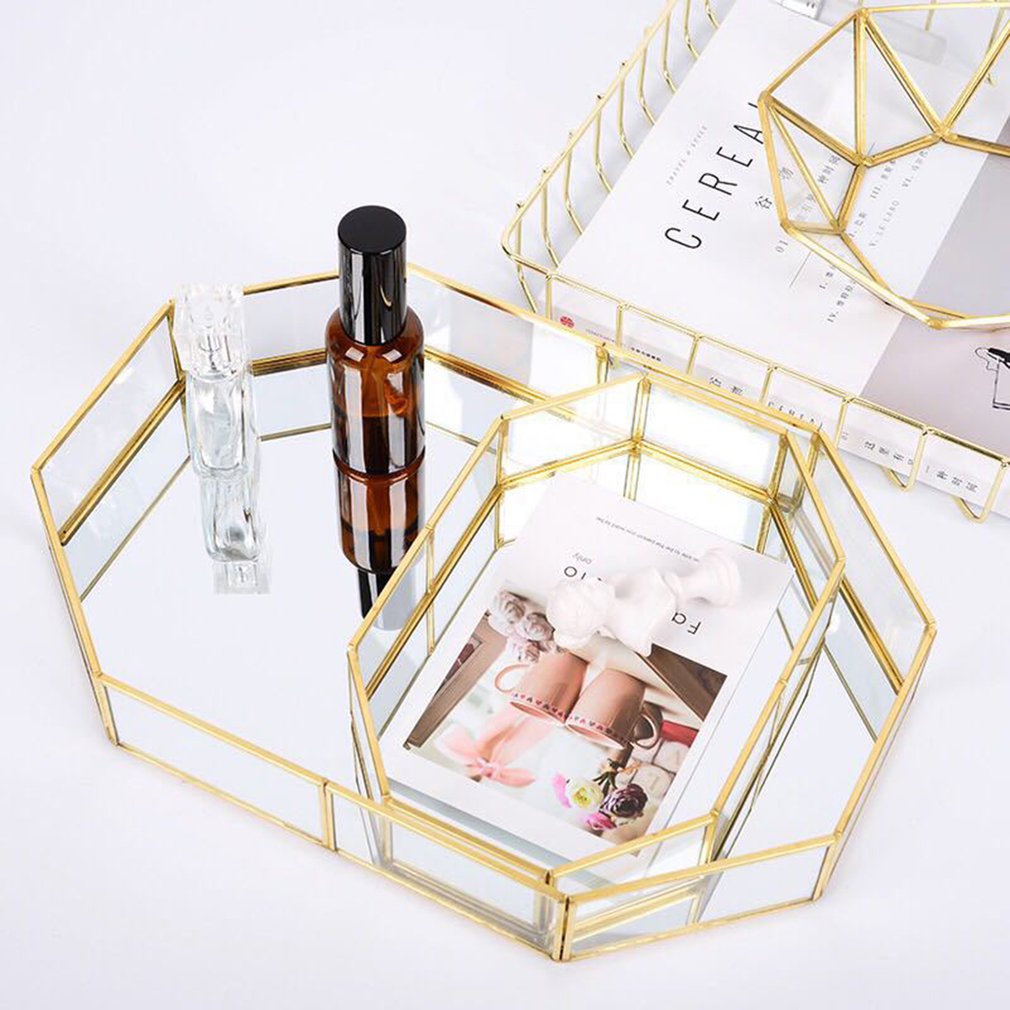 Mirrored octagonal tray with brass frame holding perfume