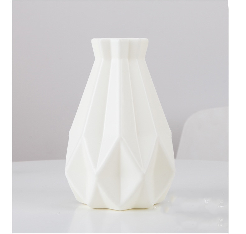 Light faceted vase arranged with stems in a neutral interior