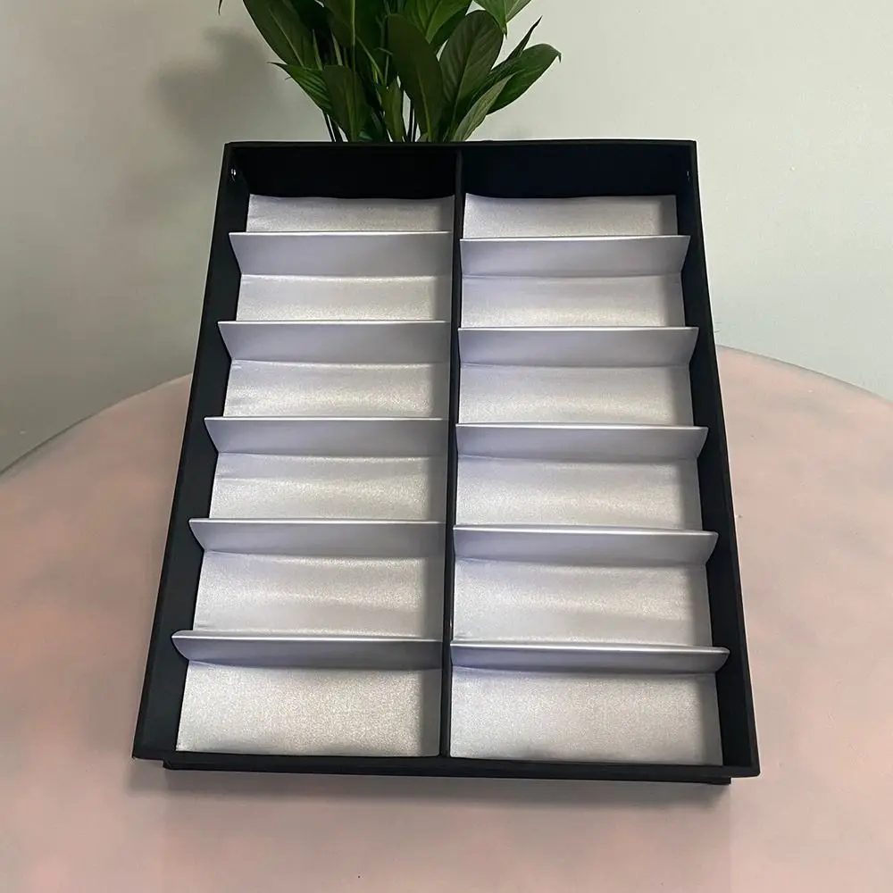 Empty case showing satin silver padded liners in every slot
