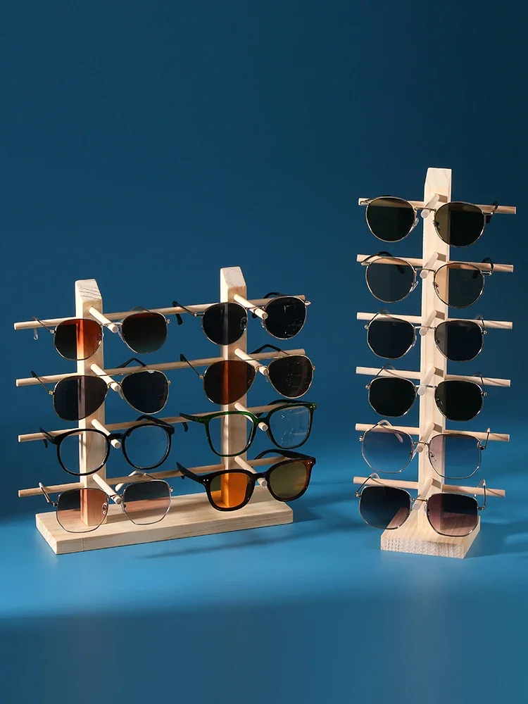 Six-tier and four-tier wooden racks loaded with sunglasses side by side
