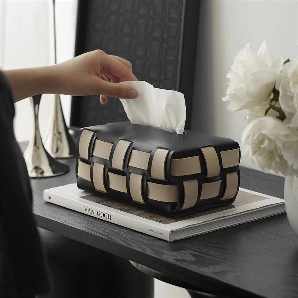 Hand pulling a tissue from a woven box beside an art book