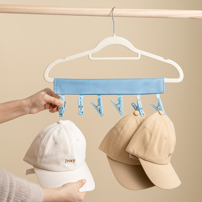 Blue clip hanger with two baseball caps clipped on by the brim