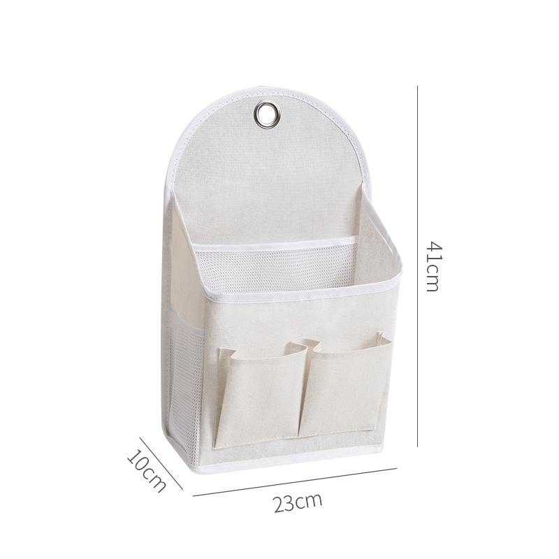 Cream hanging fabric wall organizer with metal hanging ring at the top