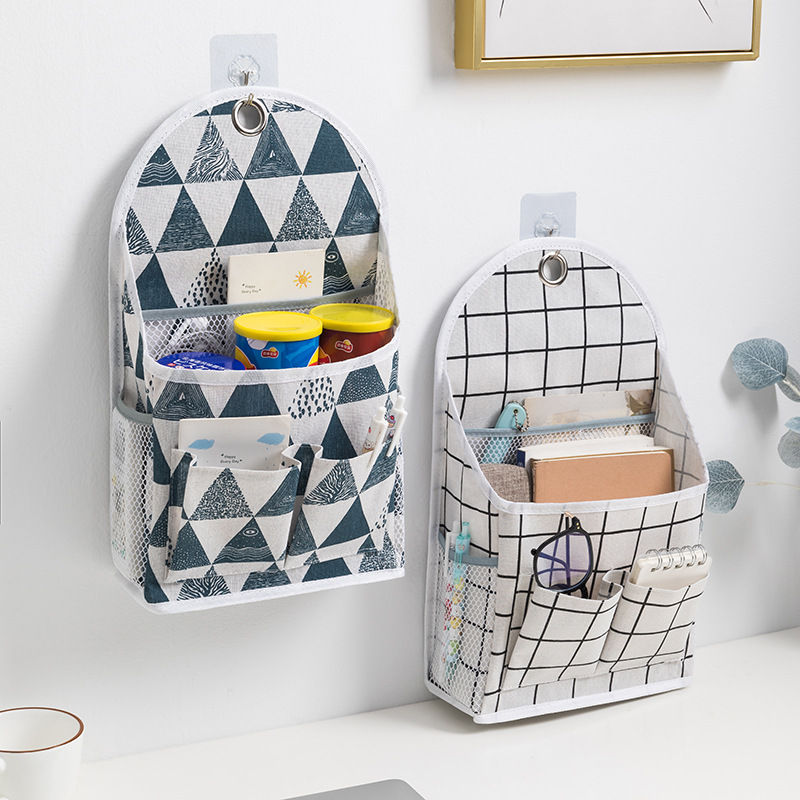 Navy triangle print and black grid hanging fabric organizers beside a study desk