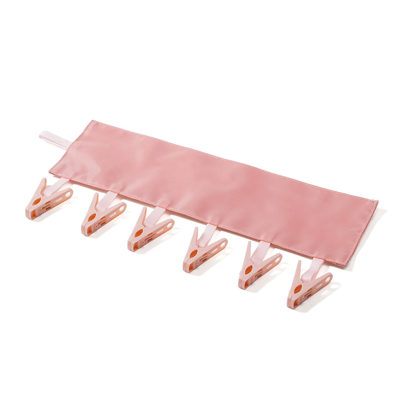 Pink fabric clip bar laid flat with six pink spring clips