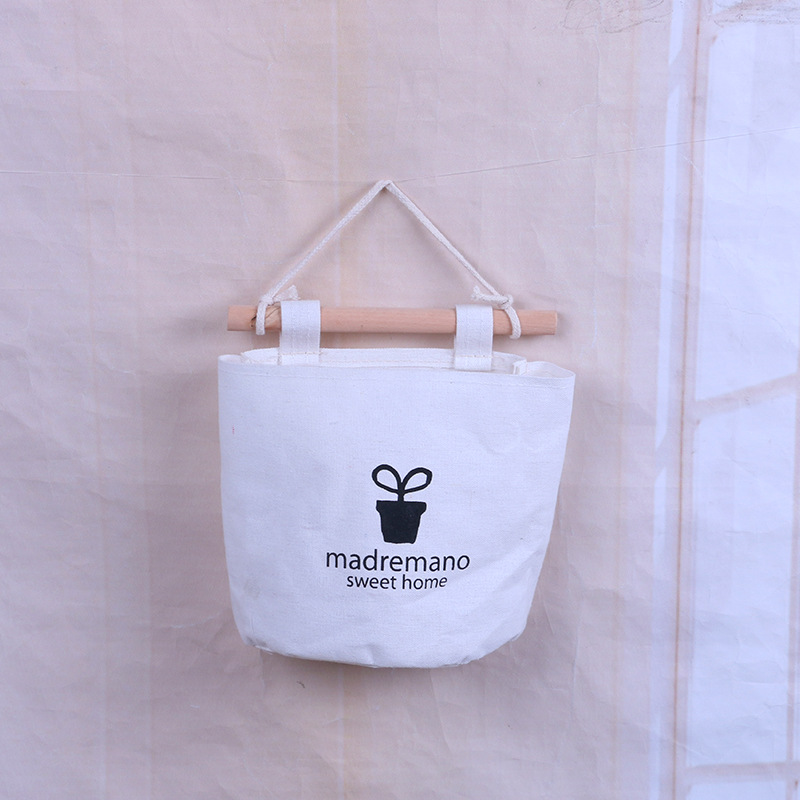 Canvas storage bag hanging on wall with rope loop and fabric tabs