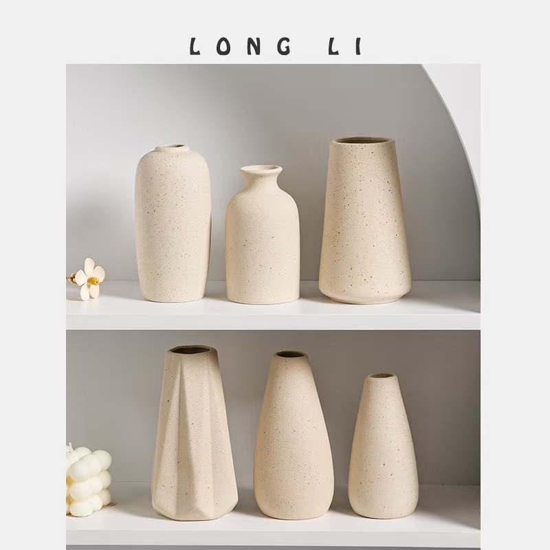 Six cream ceramic vases in varied shapes across two shelf levels