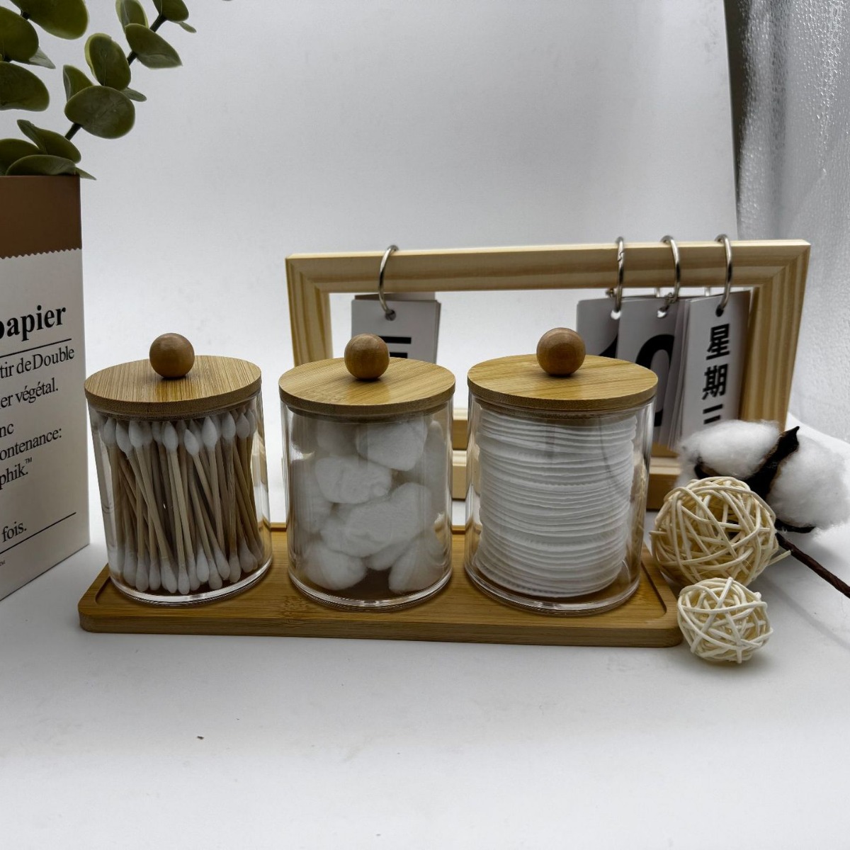 Three clear bamboo-lid jars on a bamboo tray in a bright vanity