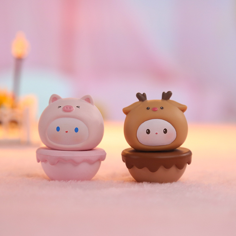 Brown deer and pink pig figurines on a cosy surface