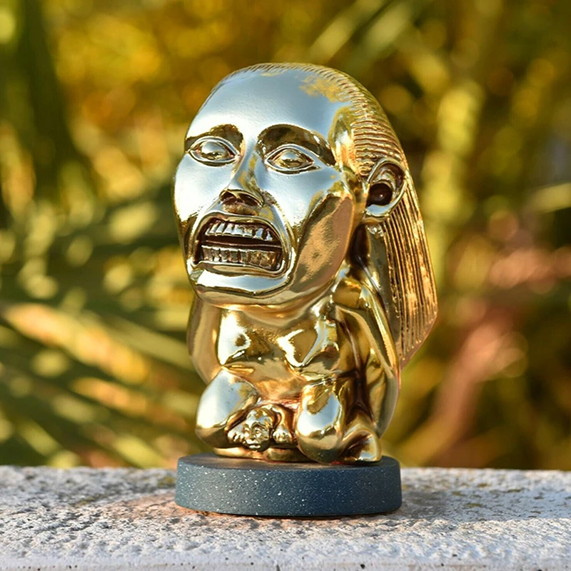 Glossy chrome-gold idol statue with reflective metallic finish close up