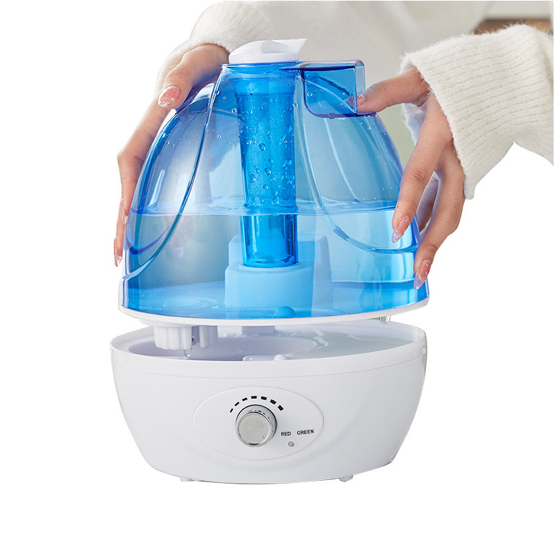 Hands lifting the clear blue tank off the white humidifier base