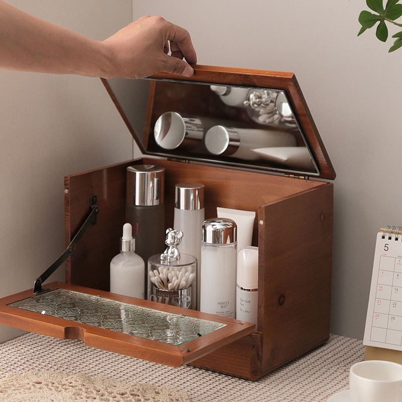 Hand lifting the mirrored lid of a wooden vanity organizer on a counter