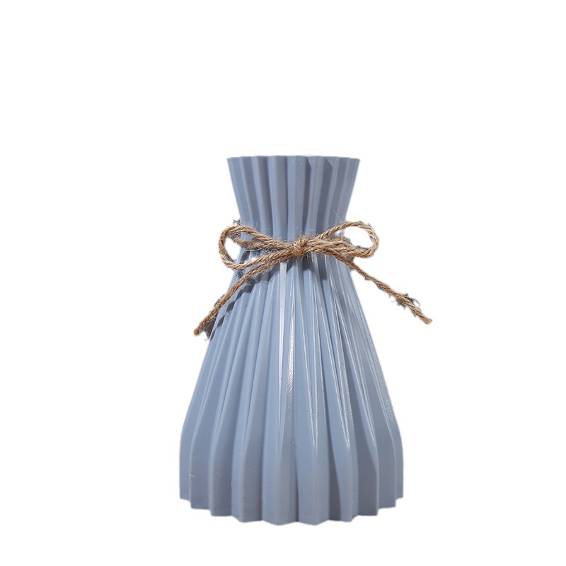 Matte pleated vase on a bare interior surface awaiting stems