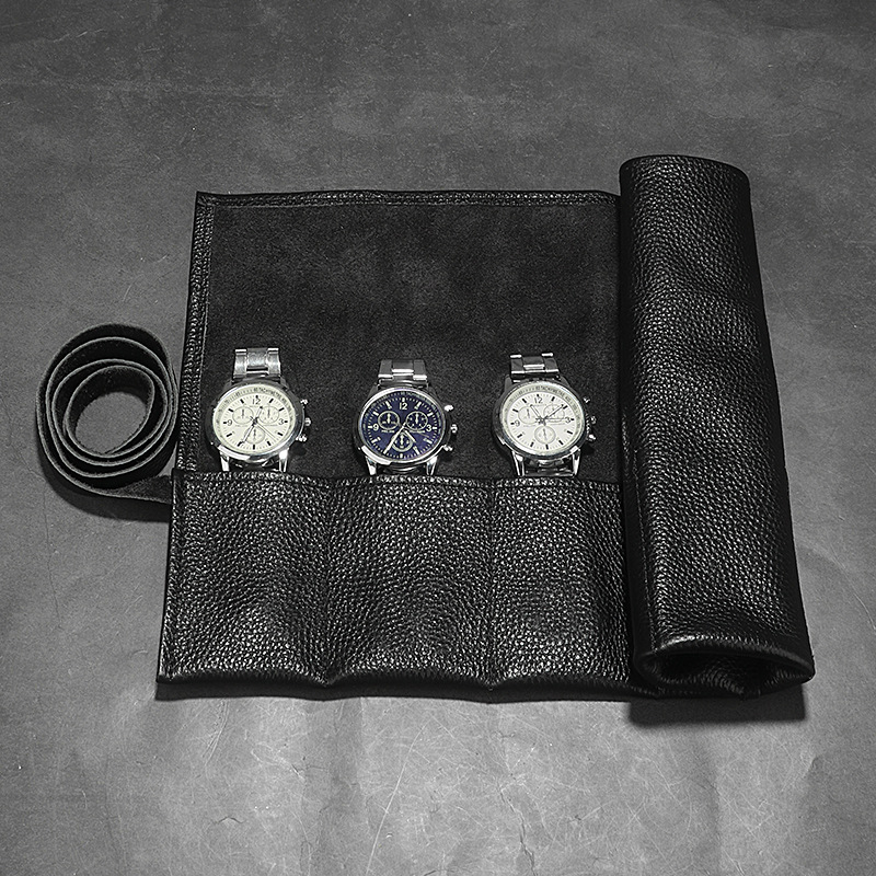 Black 3-slot watch roll open with three watches and padded dividers